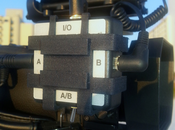 Camera Mount For Sescom Audio Switch With Clip Bar 3d printed A photo of the prototype print in black nylon.  