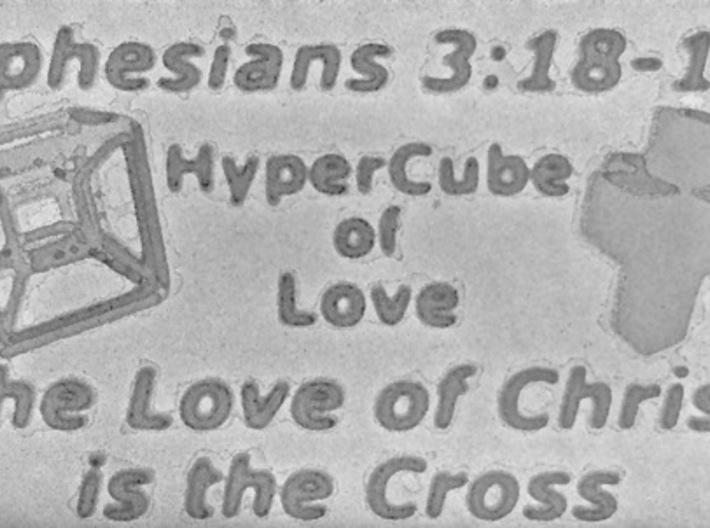 Plaque HyperCube  (60 x 36 mm) 3d printed The Plaque (60 mm x 36 mm) viewed through a frosted window shows the embossed 3D Cross and HyperCube