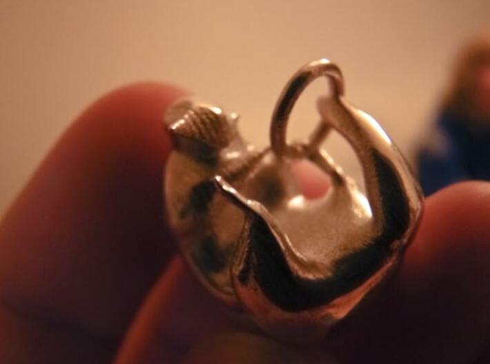 Lovely Raccoon Pendant 3d printed The pendant being held between fingers.