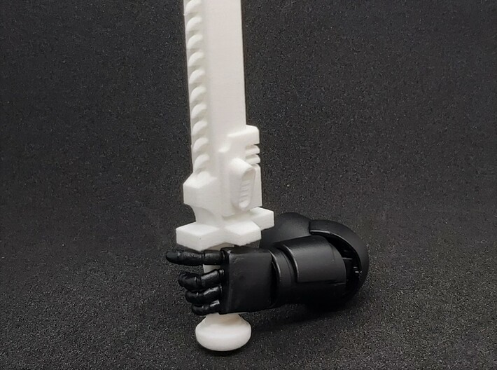 Action Figure Chainsword - Left Handed 3d printed Printed in White Natural Versatile Plastic, held by the hand of a 1:12 scale action figure arm